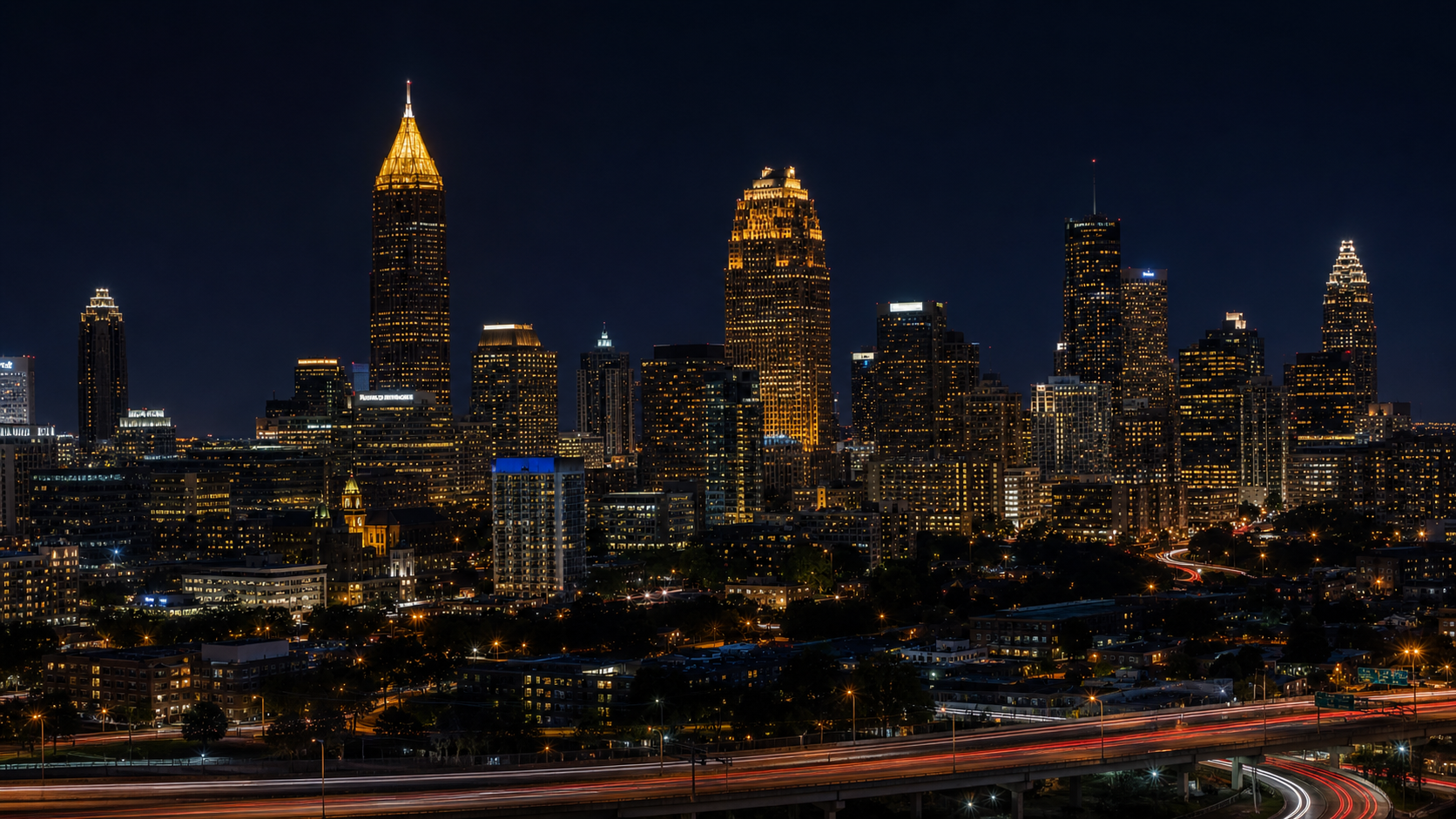 Atlanta skyline glowing at night with blurred traffic below